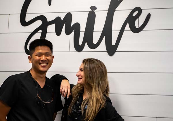 Cosmetic Dentistry Team in front of Smile Sign at Dickerson Dental