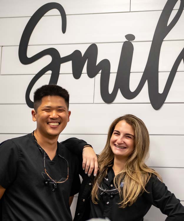 Dickerson Dental Team Members Standing in Front of Smile Sign